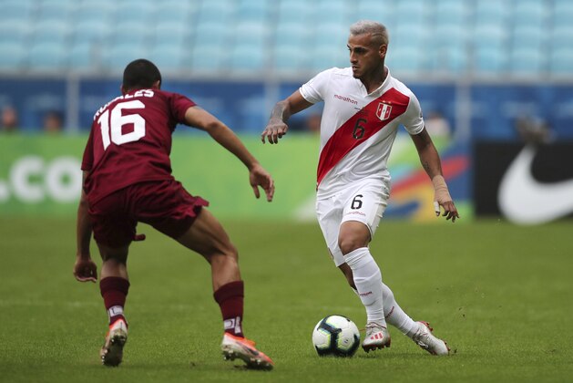 Peru's Miguel Angel Trauco, right, battles for the ball with Venezuela's Roberto Rosales during a Copa America Group A soccer match at the Arena do Gremio in Porto Alegre, Brazil, Saturday, June 15, 2019. (AP Photo/Edison Vara)