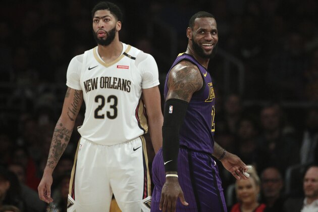 Los Angeles Lakers' LeBron James, right, smiles as he walks past New Orleans Pelicans' Anthony Davis during the first half of an NBA basketball game Friday, Dec. 21, 2018, in Los Angeles. (AP Photo/Jae C. Hong)