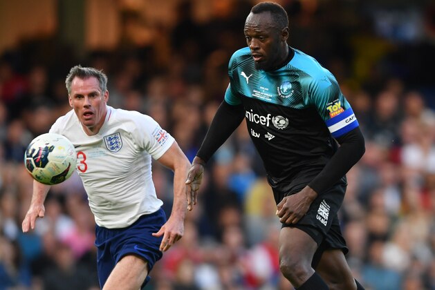LONDON, ENGLAND - JUNE 16:  Usain Bolt of Soccer Aid World XI takes on Jamie Carragher of England during the Soccer Aid for UNICEF 2019 match between England and the Soccer Aid World XI at Stamford Bridge on June 16, 2019 in London, England. (Photo by Mike Hewitt/Getty Images)