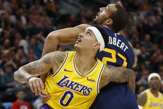 Utah Jazz center Rudy Gobert (27) and Los Angeles Lakers forward Kyle Kuzma (0) battle for position under the basket during the second half of an NBA basketball game Wednesday, March 27, 2019, in Salt Lake City. (AP Photo/Rick Bowmer)