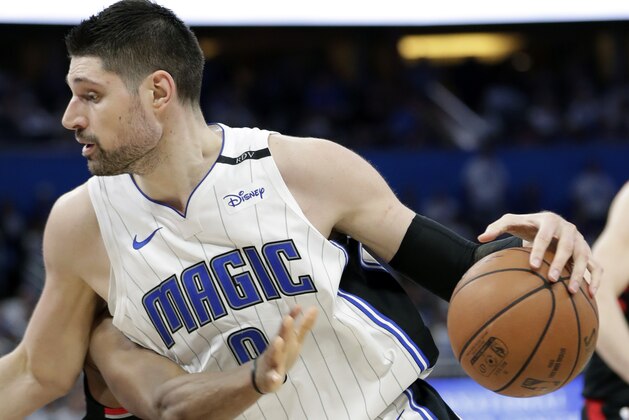 Toronto Raptors' Kyle Lowry's arm, left, reaches in to try to stop Orlando Magic's Nikola Vucevic for getting to the basket during the second half in Game 3 of a first-round NBA basketball playoff series, Friday, April 19, 2019, in Orlando, Fla. (AP Photo/John Raoux)