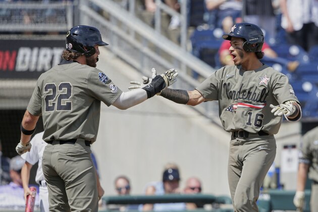 Vanderbilt's Austin Martin (16) is greeted by Julian Infante (22) after hitting a two-run home run against Louisville in the seventh inning of an NCAA College World Series baseball game in Omaha, Neb., Sunday, June 16, 2019. (AP Photo/Nati Harnik)