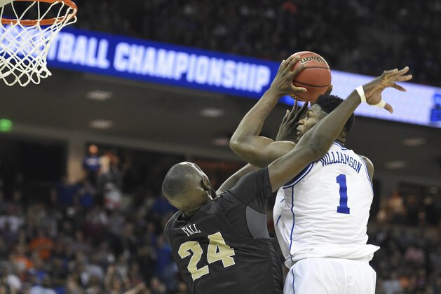 Duke's Zion Williamson (1) shoots while defended by Central Florida's Tacko Fall (24) during the second half of a second round men's college basketball game in the NCAA Tournament in Columbia, S.C. Sunday, March 24, 2019. (AP Photo/Richard Shiro)