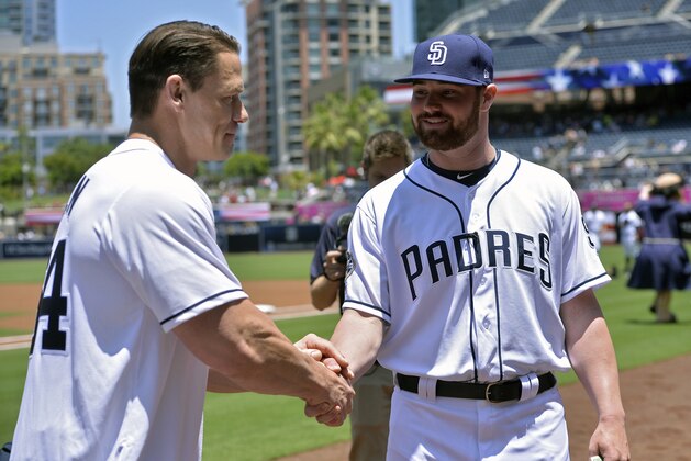 Actor and wrestler John Cena, left, shakes hands with San Diego Padres' Logan Allen after Cena payed a lost bet to Allen during the first inning of a baseball game between the Padres and the Milwaukee Brewers Wednesday, June 19, 2019, in San Diego. (AP Photo/Orlando Ramirez)