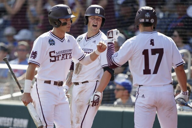 Mississippi State's Jake Mangum, left, is greeted by teammates, including Justin Foscue (17), after he scored against Vanderbilt on a double by Tanner Allen during the seventh inning of an NCAA College World Series baseball game in Omaha, Neb., Wednesday, June 19, 2019. (AP Photo/Nati Harnik)