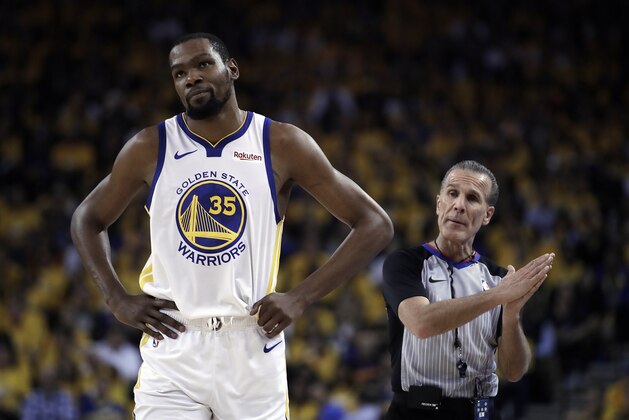 FILE - In this Wednesday, May 8, 2019, file photo, Golden State Warriors' Kevin Durant, left, walks away from referee Ken Mauer during the first half of Game 5 of the team's second-round NBA basketball playoff series against the Houston Rockets in Oakland, Calif. Durant is yet to progress to on-court work in his recovery from a strained right calf and won't be ready to return for Golden State in Game 1 of the NBA Finals on May 30. (AP Photo/Ben Margot, File)