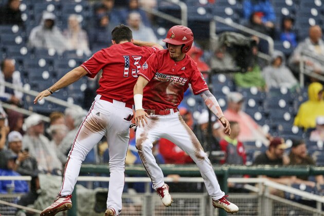 Louisville's Drew Campbell, right, celebrates with Alex Binelas (13) after scoring against Auburn on a fielding error in the fourth inning of an NCAA College World Series baseball game in Omaha, Neb., Tuesday, June 18, 2019. (AP Photo/Nati Harnik)