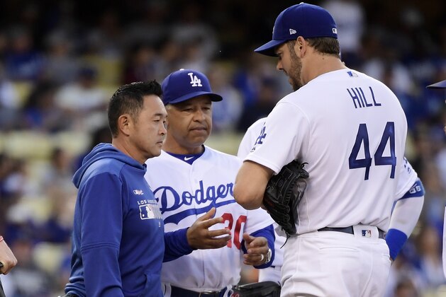 Los Angeles Dodgers starting pitcher Rich Hill, right, is taken out of the game by manager Dave Roberts, center, due to an injury prior to the second inning of the team's baseball game against the San Francisco Giants on Wednesday, June 19, 2019, in Los Angeles. (AP Photo/Mark J. Terrill)