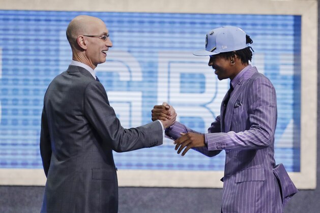 Murray State's Ja Morant, right, is greeted by NBA Commissioner Adam Silver after being selected by the Memphis Grizzlies with the second pick in the NBA basketball draft Thursday, June 20, 2019, in New York. (AP Photo/Julio Cortez)