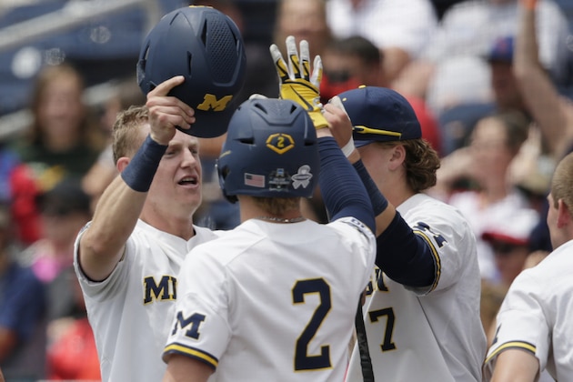 Michigan's Jimmy Kerr, left, is greeted by Jack Blomgren (2) and Jesse Franklin (7) at the dugout after scoring a run against Texas Tech on an RBI double by Blake Nelson in the first inning of an NCAA College World Series baseball game in Omaha, Neb., Friday, June 21, 2019. (AP Photo/Nati Harnik)