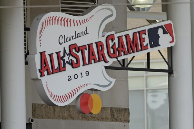 The 2019 All Star Game logo hangs above fans during the sixth inning in a baseball game between the Cincinnati Reds and the Cleveland Indians, Wednesday, June 12, 2019, in Cleveland. (AP Photo/Tony Dejak)