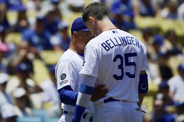 Los Angeles Dodgers manager Dave Roberts, left, talks with Cody Bellinger after Bellinger hit a fan with a foul ball during the first inning of a baseball game against the Colorado Rockies, Sunday, June 23, 2019, in Los Angeles. (AP Photo/Mark J. Terrill)
