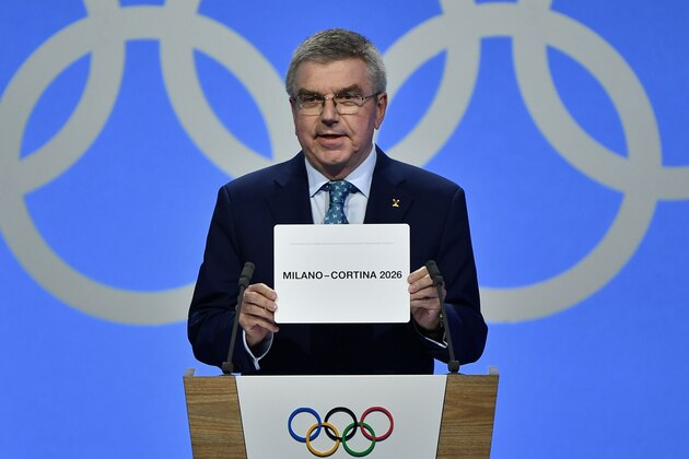 International Olympic Committee (IOC) president Thomas Bach shows the card with the name Milan/Cortina d'Ampezzo as the winning name of the 2026 Winter Olympics during the 134th session of the International Olympic Committee (IOC), in Lausanne on June 24, 2019. (Photo by Fabrice COFFRINI / AFP)        (Photo credit should read FABRICE COFFRINI/AFP/Getty Images)
