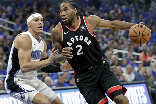 Toronto Raptors' Kawhi Leonard (2) drives to the basket against Orlando Magic's Aaron Gordon, left, during the first half in Game 4 of a first-round NBA basketball playoff series, Sunday, April 21, 2019, in Orlando, Fla. (AP Photo/John Raoux)
