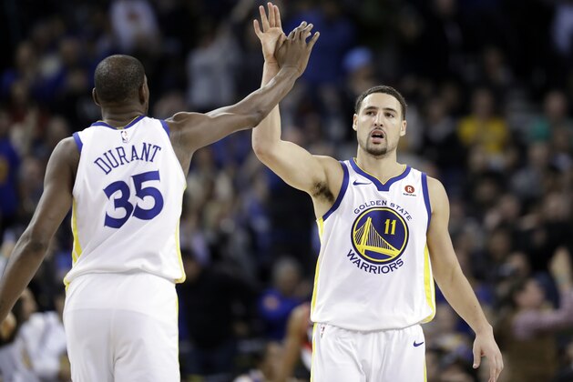Golden State Warriors' Klay Thompson (11) high fives teammate Kevin Durant during the second half of an NBA basketball game against the Portland Trail Blazers Monday, Dec. 11, 2017, in Oakland, Calif. (AP Photo/Marcio Jose Sanchez)