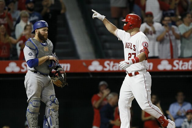 Los Angeles Angels' Mike Trout, right, points after hitting a two-run home run with Los Angeles Dodgers catcher Russell Martin watching during the seventh inning of a baseball game against the Los Angeles Dodgers in Anaheim, Calif., Monday, June 10, 2019. (AP Photo/Alex Gallardo)