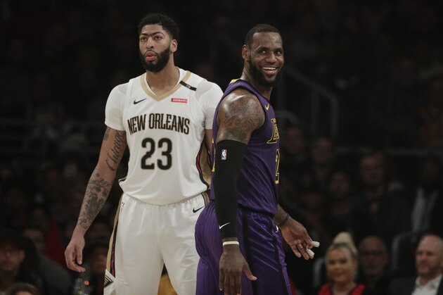 Los Angeles Lakers' LeBron James, right, smiles as he walks past New Orleans Pelicans' Anthony Davis during the first half of an NBA basketball game, Friday, Dec. 21, 2018, in Los Angeles. (AP Photo/Jae C. Hong)