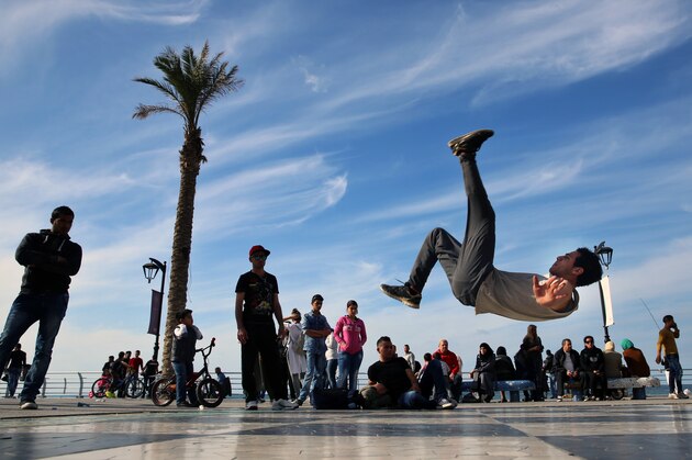 Syrian refugee Mohammed al-Shareef, 20, who fled with his family from Damascus, Syria, performs a breakdance on the Mediterranean waterfront promenade in Beirut, Lebanon, Sunday, March 6, 2016. (AP Photo/Bilal Hussein)