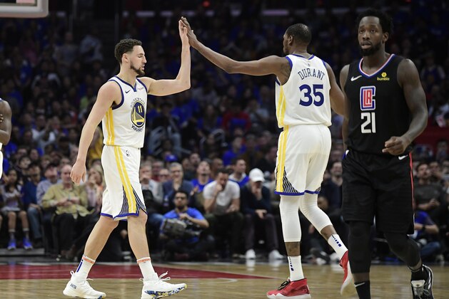 Golden State Warriors guard Klay Thompson, left, and forward Kevin Durant, center, congratulate each other as Los Angeles Clippers guard Patrick Beverley walks by during the second half in Game 4 of a first-round NBA basketball playoff series Sunday, April 21, 2019, in Los Angeles. The Warriors won 113-105. (AP Photo/Mark J. Terrill)
