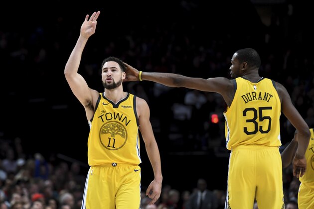 Golden State Warriors guard Klay Thompson, left, is patted on his head by forward Kevin Durant, right, after hitting a shot late in an NBA basketball game against the Portland Trail Blazers in Portland, Ore., Saturday, Dec. 29, 2018. The Warriors won 115-105. (AP Photo/Steve Dykes)