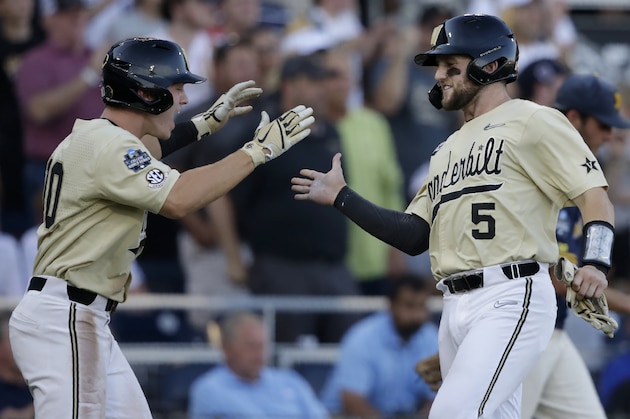Vanderbilt's Philip Clarke, right, and Ethan Paul celebrate after both scored on a single by Stephen Scott during the third inning of Game 3 of the NCAA College World Series baseball finals against Michigan in Omaha, Neb., Wednesday, June 26, 2019. (AP Photo/Nati Harnik)