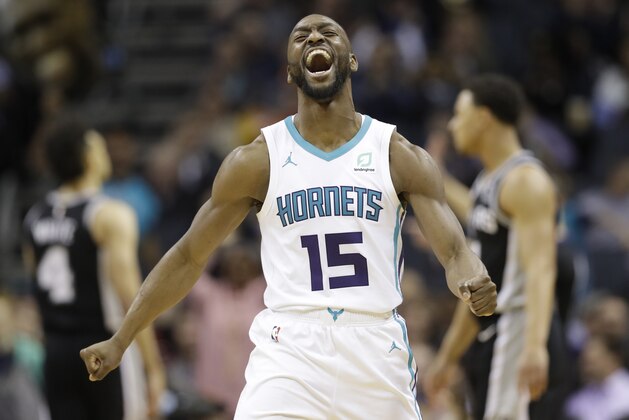 FILE - In this March 26, 2019, file photo, Charlotte Hornets' Kemba Walker (15) reacts after making a basket against the San Antonio Spurs during the second half of an NBA basketball game in Charlotte, N.C. The three-time All-Star point says he’d be willing to work with the Hornets and take less than the “supermax” $221 million contract he’s eligible to receive to re-sign with Charlotte (AP Photo/Chuck Burton, File)