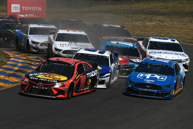 SONOMA, CALIFORNIA - JUNE 23: Martin Truex Jr., driver of the #19 Bass Pro Shops Toyota, and Ryan Blaney, driver of the #12 PPG Ford, lead a pack of cars during the Monster Energy NASCAR Cup Series Toyota/Save Mart 350 at Sonoma Raceway on June 23, 2019 in Sonoma, California. (Photo by Robert Reiners/Getty Images)