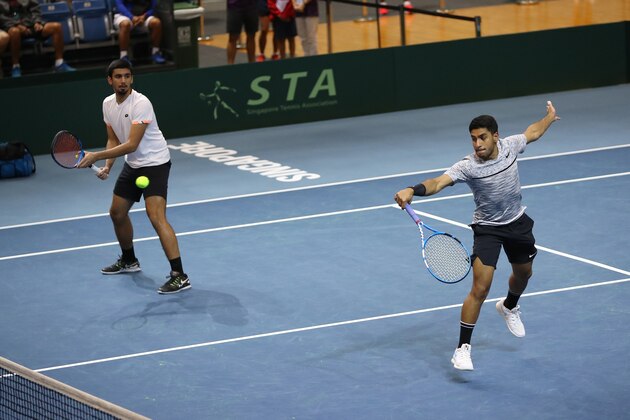 SINGAPORE, SINGAPORE - JUNE 26: Abdulrahman Alawadhi and Essa Qabazard of Kuwait in action during their Pool A mens doubles match against Roy Hobbs and Jensen Hiu of Singapore during day one of the Davis Cup Asia/Oceania Group III at OCBC Arena on June 26, 2019 in Singapore. (Photo by Lionel Ng/Getty Images for Singapore Sports Hub)