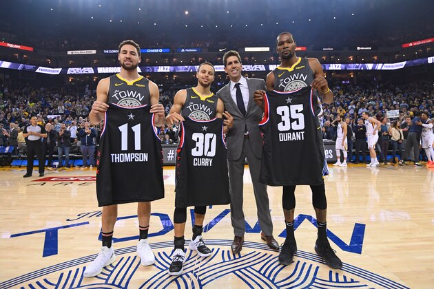 OAKLAND, CA - FEBRUARY 12: Klay Thompson #11, Stephen Curry #30 and Kevin Durant #35 of the Golden State Warriors pose for a photo with Bob Meyers holding up their Charlotte All-Star jersey's before the game against the Utah Jazz on February 12, 2019 at ORACLE Arena in Oakland, California. NOTE TO USER: User expressly acknowledges and agrees that, by downloading and or using this photograph, user is consenting to the terms and conditions of Getty Images License Agreement. Mandatory Copyright Notice: Copyright 2019 NBAE (Photo by Noah Graham/NBAE via Getty Images)