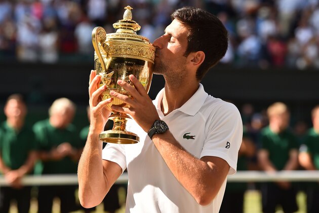 Serbia's Novak Djokovic kisses the winners trophy after beating South Africa's Kevin Anderson 6-2, 6-2, 7-6 in their men's singles final match on the thirteenth day of the 2018 Wimbledon Championships at The All England Lawn Tennis Club in Wimbledon, southwest London, on July 15, 2018. (Photo by Glyn KIRK / AFP) / RESTRICTED TO EDITORIAL USE        (Photo credit should read GLYN KIRK/AFP/Getty Images)