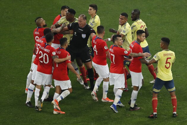 Referee Nestor Pitana separates the players of Chile and Colombia during a Copa America quarterfinal soccer match at the Arena Corinthians in Sao Paulo, Brazil, Friday, June 28, 2019. (AP Photo/Nelson Antoine)