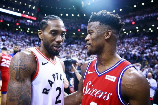 TORONTO, ON - MAY 12:  Kawhi Leonard #2 of the Toronto Raptors speaks with Jimmy Butler #23 of the Philadelphia 76ers after sinking a buzzer beater to win Game Seven of the second round of the 2019 NBA Playoffs at Scotiabank Arena on May 12, 2019 in Toronto, Canada.  NOTE TO USER: User expressly acknowledges and agrees that, by downloading and or using this photograph, User is consenting to the terms and conditions of the Getty Images License Agreement.  (Photo by Vaughn Ridley/Getty Images)