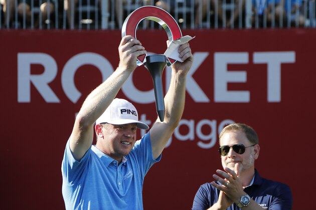 Nate Lashley raises the winner's trophy after the final round of the Rocket Mortgage Classic golf tournament, Sunday, June 30, 2019, in Detroit. (AP Photo/Carlos Osorio)