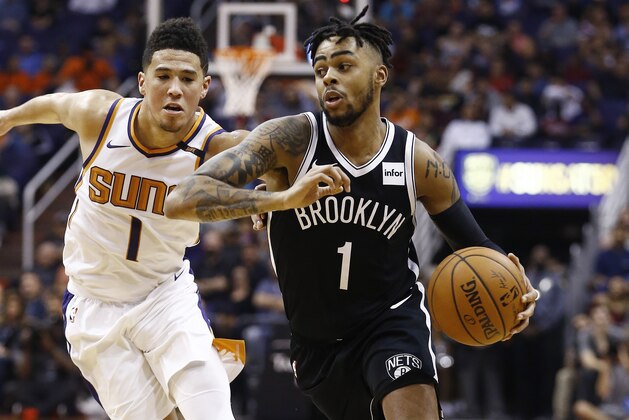 Brooklyn Nets guard D'Angelo Russell, right, drives past Phoenix Suns guard Devin Booker, left, during the first half of an NBA basketball game Monday, Nov. 6, 2017, in Phoenix. The Nets defeated the Suns 98-92. (AP Photo/Ross D. Franklin)