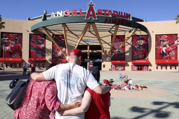 Los Angeles Angel mourners stand at a memorial to give their condolences for pitcher Tyler Skaggs at Angel Stadium in Anaheim, Calif., Monday, July 1, 2019. Skaggs died at the age of 27, stunning Major League Baseball and leading to the postponement of the team's game against the Texas Rangers on Monday. (AP Photo/Alex Gallardo) Los Angeles Angel mourners stand at a memorial to give their condolences for pitcher Tyler Skaggs at Angel Stadium in Anaheim, Calif., Monday, July 1, 2019. Skaggs died at the age of 27, stunning Major League Baseball and leading to the postponement of the team's game against the Texas Rangers on Monday. (AP Photo/Alex Gallardo)