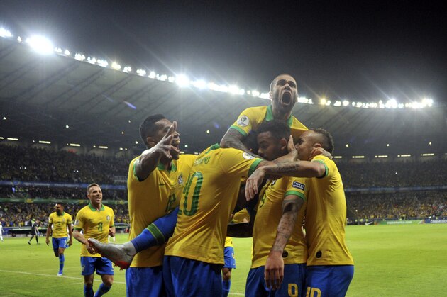 Brazil's Dani Alves, top, jumps on top of his teammates after teammate Gabriel Jesus scored their team's first goal against Argentina during a Copa America semifinal soccer match at Mineirao stadium in Belo Horizonte, Brazil, Tuesday, July 2, 2019. (AP Photo/Eugenio Savio)