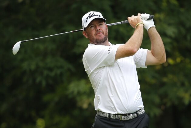 Robert Garrigus watches his tee shot on the sixth hole during the first round of the John Deere Classic golf tournament Thursday, July 9, 2015, in Silvis , Ill. (AP Photo/Charles Rex Arbogast)