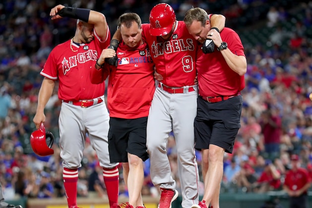 ARLINGTON, TEXAS - JULY 02: Team personnel assist Tommy La Stella #9 of the Los Angeles Angels after he was injured while at bat against the Texas Rangers in the top of the sixth inning at Globe Life Park in Arlington on July 02, 2019 in Arlington, Texas. (Photo by Tom Pennington/Getty Images)