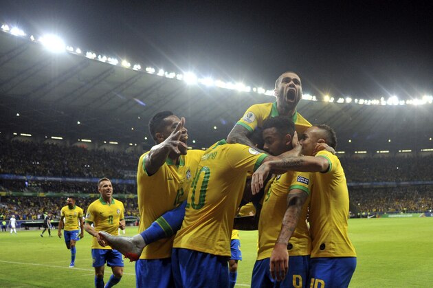 Brazil's Dani Alves, top, jumps on top of his teammates after teammate Gabriel Jesus scored their team's first goal against Argentina during a Copa America semifinal soccer match at Mineirao stadium in Belo Horizonte, Brazil, Tuesday, July 2, 2019. (AP Photo/Eugenio Savio)