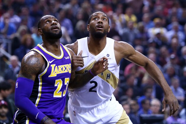 TORONTO, ON - MARCH 14:  LeBron James #23 of the Los Angeles Lakers battles for space with Kawhi Leonard #2 of the Toronto Raptors during the first half of an NBA game at Scotiabank Arena on March 14, 2019 in Toronto, Canada.  NOTE TO USER: User expressly acknowledges and agrees that, by downloading and or using this photograph, User is consenting to the terms and conditions of the Getty Images License Agreement.  (Photo by Vaughn Ridley/Getty Images)