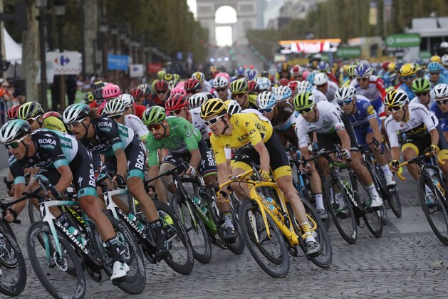 Tour de France winner Britain's Geraint Thomas, wearing the overall leader's yellow jersey, and Slovakia's Peter Sagan, wearing the best sprinter's green jersey, ride down Chams Elysees avenue as the Arc de Triomphe is seen in the background during the twenty-first stage of the Tour de France cycling race over 116 kilometers (72.1 miles) with start in Houilles and finish on Champs-Elysees avenue in Paris, France, Sunday July 29, 2018. (AP Photo/Christophe Ena )