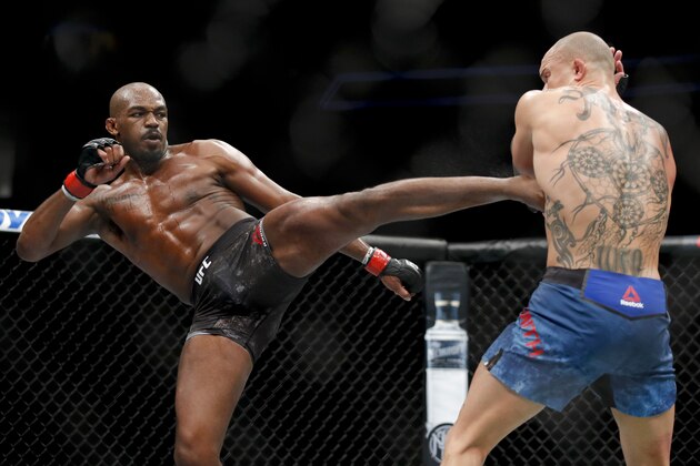 Jon Jones, left, kicks Anthony Smith during a light heavyweight mixed martial arts title bout at UFC 235, Saturday, March 2, 2019, in Las Vegas. (AP Photo/John Locher)