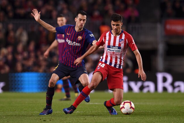 BARCELONA, SPAIN - APRIL 06:  Rodri of Atletico Madrid evades Sergio Busquets of Barcelona during the La Liga match between FC Barcelona and  Club Atletico de Madrid at Camp Nou on April 06, 2019 in Barcelona, Spain. (Photo by Alex Caparros/Getty Images)