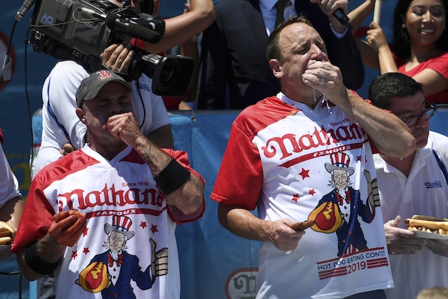 Geoffrey Esper, left, and Joey Chestnut, right, compete during the men's competition of Nathan's Famous July Fourth hot dog eating contest, Thursday, July 4, 2019, in New York's Coney Island. (AP Photo/Sarah Stier)