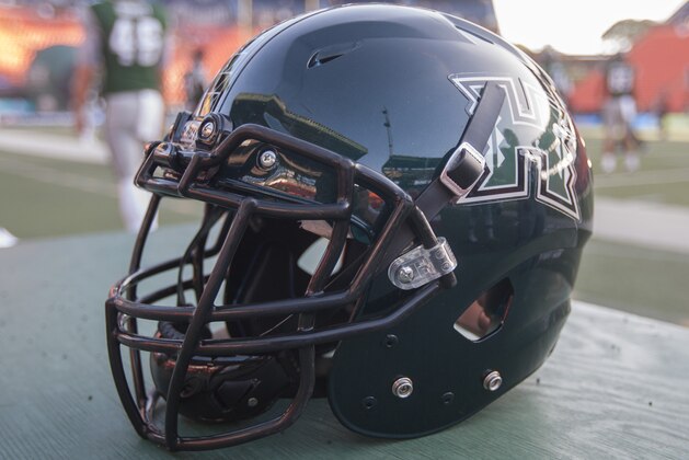 A Hawaii football helmet sits on a case before the start of an NCAA college football game, Saturday, Sept. 19, 2015, in Honolulu. (AP Photo/Eugene Tanner)