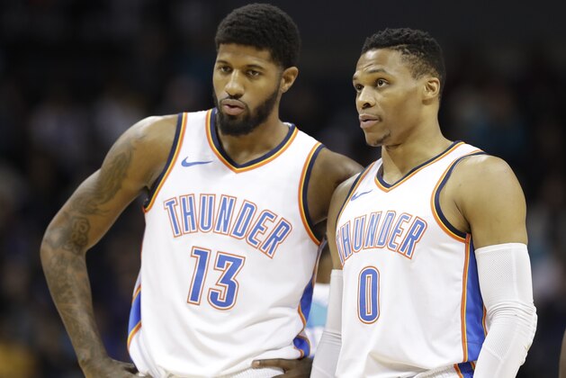 Oklahoma City Thunder's Paul George (13) talks with Russell Westbrook (0) during the first half of an NBA basketball game against the Charlotte Hornets in Charlotte, N.C., Saturday, Jan. 13, 2018. (AP Photo/Chuck Burton)