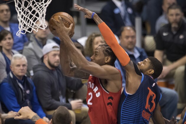 Toronto Raptors forward Kawhi Leonard (2) shoots while defended by Oklahoma City Thunder forward Paul George (13) during the first half of an NBA basketball game Wednesday, March 20, 2019, in Oklahoma City. (AP Photo/Rob Ferguson)