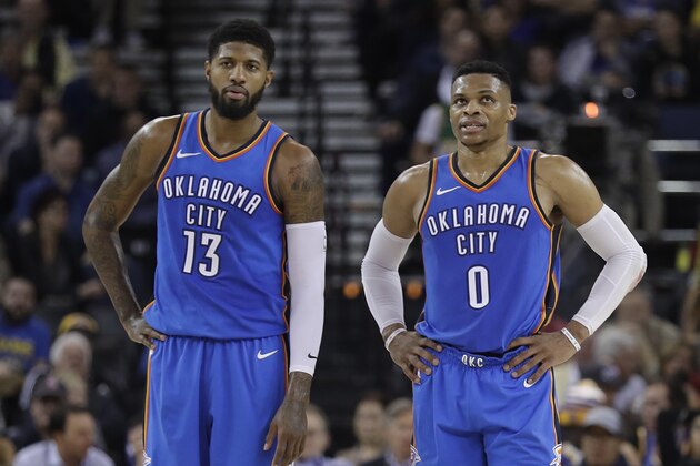 Oklahoma City Thunder's Russell Westbrook (0) stands next to teammate Paul George (13) during the first half of an NBA basketball game against the Golden State Warriors Tuesday, Feb. 6, 2018, in Oakland, Calif. (AP Photo/Marcio Jose Sanchez)