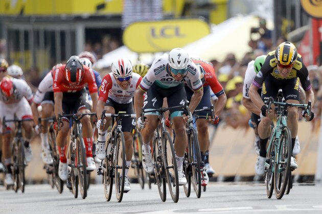 Riders with Netherlands' Mike Teunissen, right, and Slovakia's Peter Sagan, center, sprint to the finish line during the first stage of the Tour de France cycling race over 194.5 kilometers (120,86 miles) with start in Brussels and finish in Brussels. Saturday, July 6, 2019. Mike Teunissen won the stage. (AP Photo/Christophe Ena)