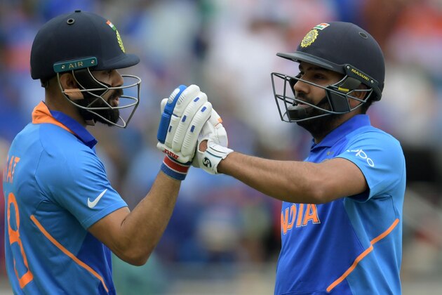 India's captain Virat Kohli (L) embraces teammate Rohit Sharma as he walks back to the pavilion after his dismissal  during the 2019 Cricket World Cup group stage match between Bangladesh and India at Edgbaston in Birmingham, central England, on July 2, 2019. (Photo by Dibyangshu Sarkar / AFP) / RESTRICTED TO EDITORIAL USE        (Photo credit should read DIBYANGSHU SARKAR/AFP/Getty Images)
